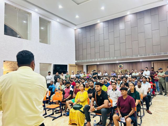 A speaker addressing a hall full of coaches, parents and officials