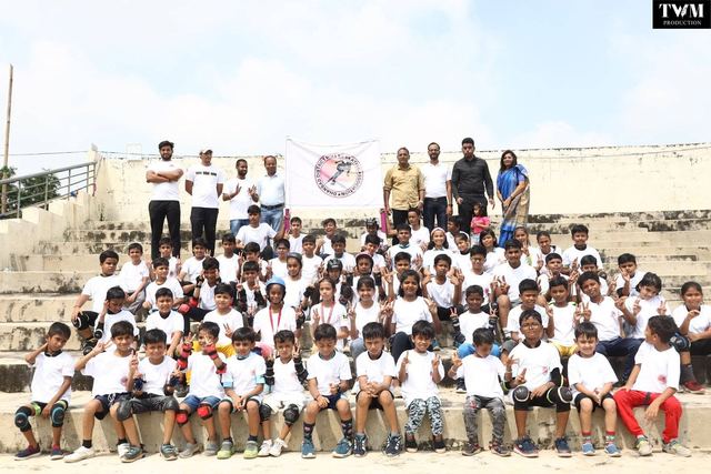 Group photo of young skaters and organisers on the stadium steps with the DDRSA flag