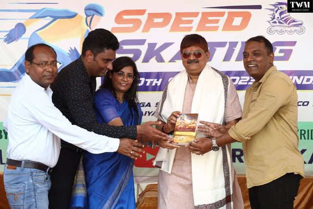 Guests presenting a gift on stage in front of the Speed Skating banner