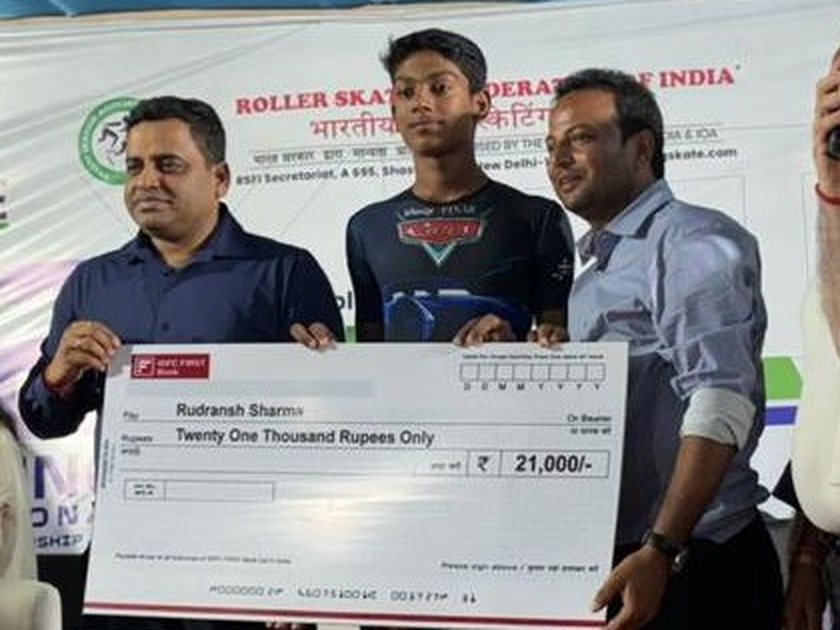 Rudransh Sharma holding a ₹21,000 cheque at a Roller Skating Federation of India event